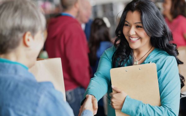 Woman shaking hands with smile and confidence in social gathering